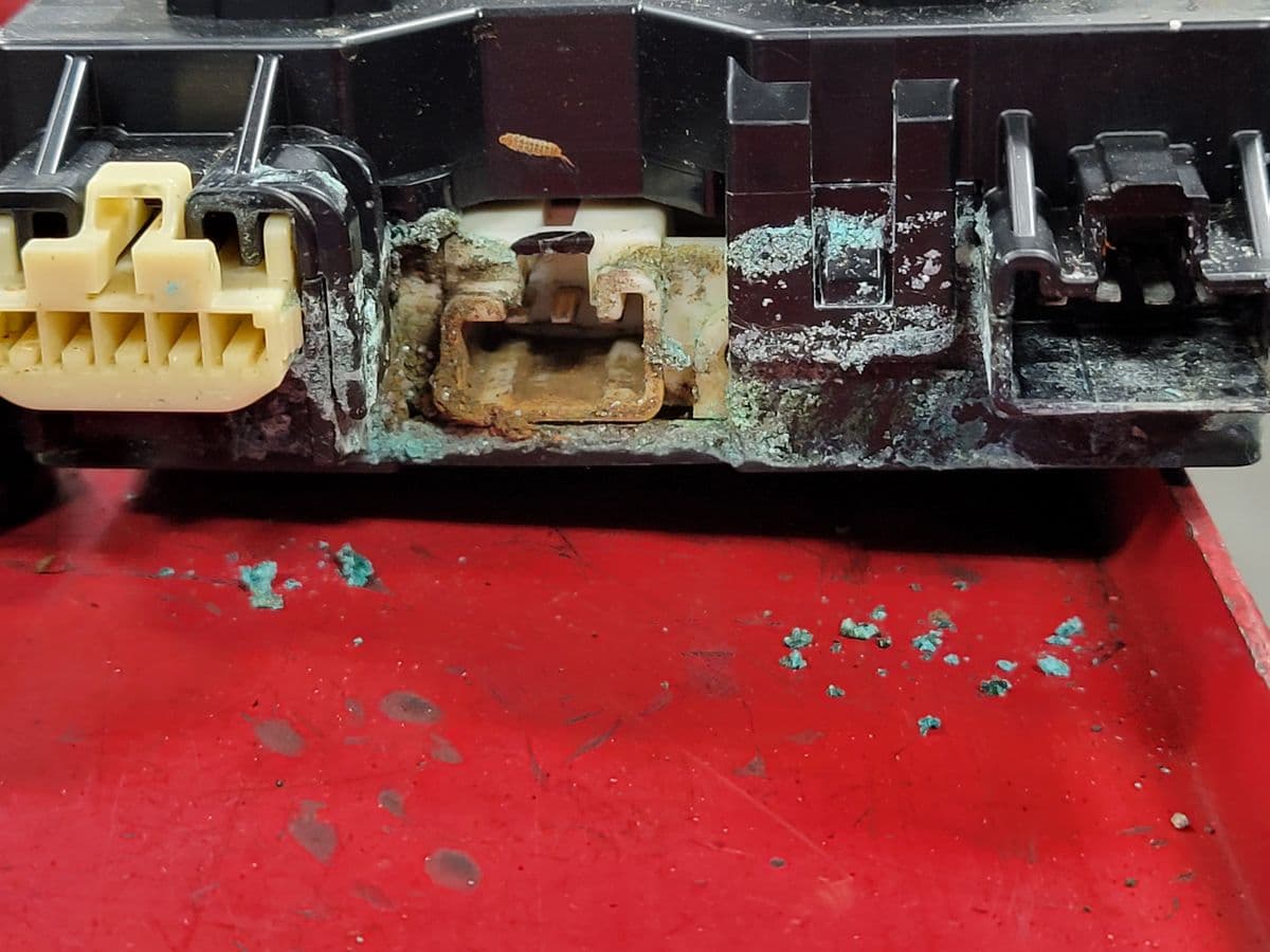 A Highlander Hybrid's system main relay block, green with corrosion, pulled on a P0AA6 diagnosis