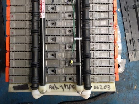 A reconditioned Prius hybrid battery with its rebuild date, 4/13/16, handwritten on the case