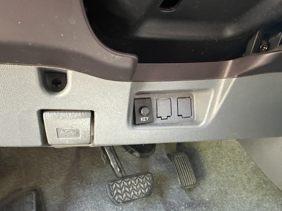 Gen 2 Prius smart key disable button labeled KEY on the lower dash near the driver's left knee