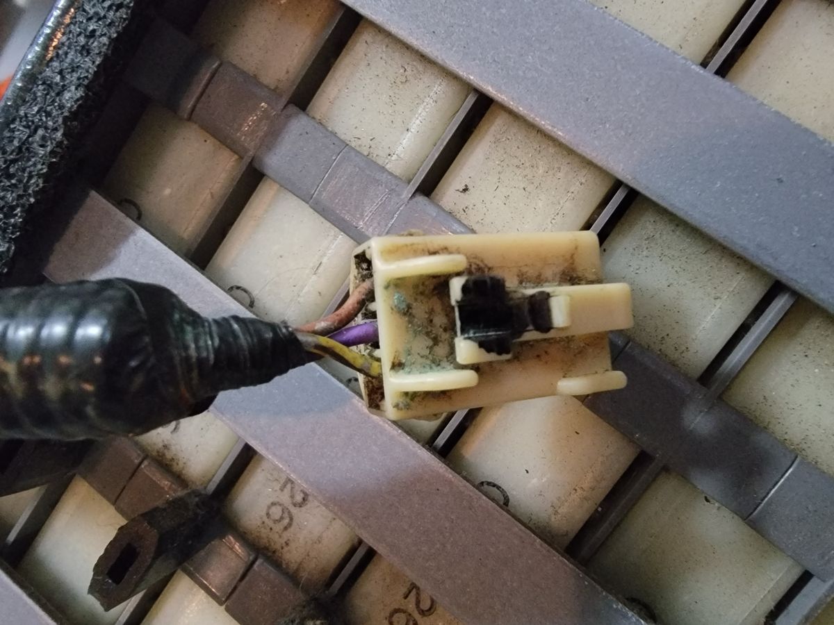 Corroded electrical connector with green and white buildup resting on the hybrid battery modules of a Toyota Highlander