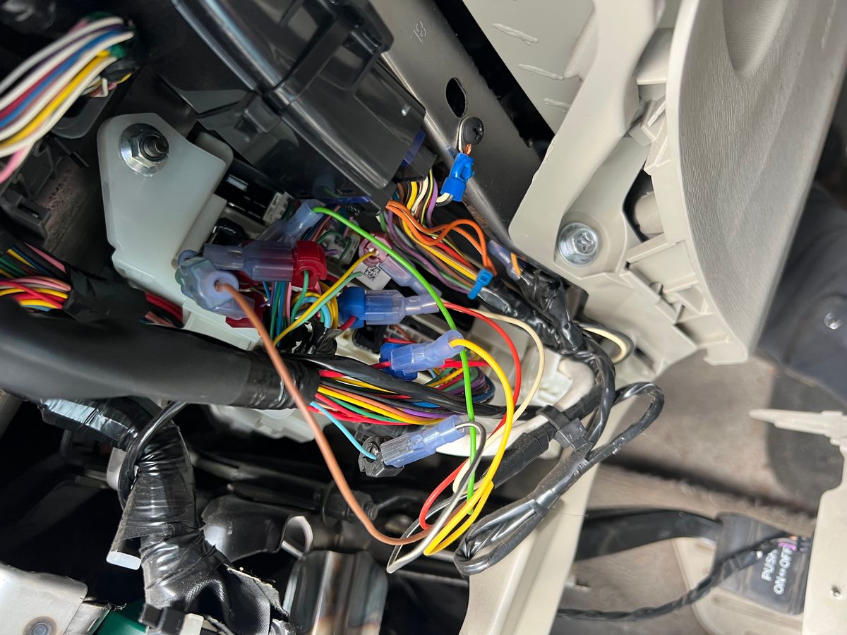 Aftermarket security system wiring piggy-backed into a 2011 Toyota Prius dash harness with dozens of crimped splice connectors