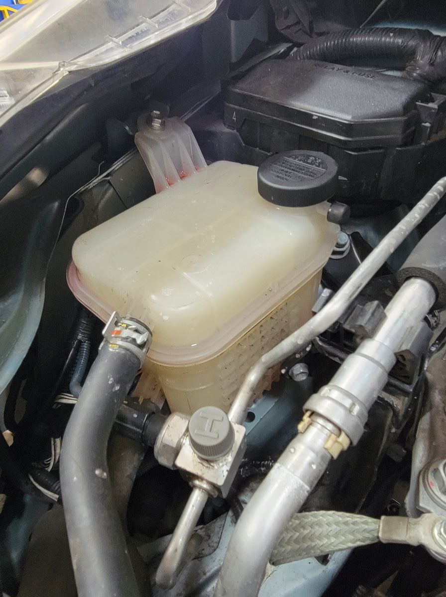 Coolant reservoir on a 2016 Toyota Prius, low because coolant was leaking into the catalytic converter